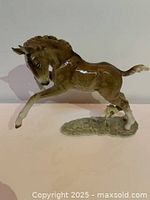 Porcelain pony figurine in prancing pose, front and left side view.