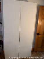 Closed view of the IKEA PAX wardrobe with white Laxviken textured doors showing subtle horizontal pattern.