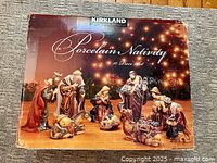 Box showing image of completed nativity set with 10 porcelain pieces
