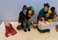 Photo showing the three Royal Doulton figurines: The Balloon Man, The Old Balloon Seller and This Little Pig