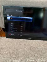 Samsung 46-inch LCD HDTV displaying source input menu including TV, PC, AV1, AV2, component 1, component 2, and HDMI/ DVI inputs.