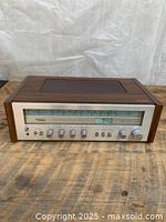 Front full view of the Technics stereo receiver showing walnut wood case and metallic front panel with all controls and tuning display.