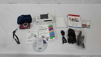 Lot overview showing camera, printer, accessories, manuals and CD