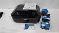 Canon Pixma MX922 printer with six Canon ink cartridge boxes displayed