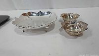 Leaf footed dish and two small ornate bowls side by side