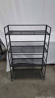 Front view of four-tier metal folding shelf