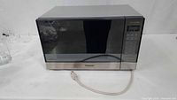 Front view of Panasonic stainless microwave with cord