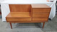 front angled view of teak gossip bench showing seat, drawers, legs