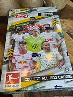 Front of sealed Topps 2021/22 Bundesliga hobby box showing player graphics and collectible details
