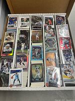 Four-row box filled with assorted sleeved and unsleeved sports trading cards