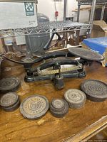 Full view of scale with accompanying weights on wooden surface