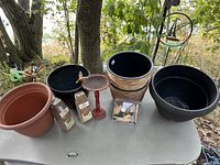 Overall shot of all pots, bird bath, seed packs and garden kit on table
