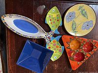 Assortment of dishes showing fish plates, Provencal plate, wood snack bowl, blue glass bowl and long fish platter
