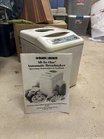 Breadmaker front view with manual displayed