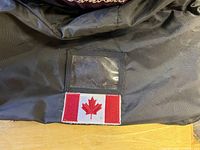 Black fabric gear bag panel with clear ID window and sewn Canadian flag patch
