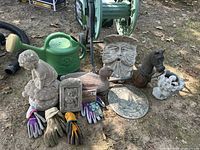 Overall lot view showing watering can, hose reel, sculptures, gloves