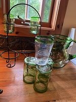 Glass pitcher, several glasses and metal rack on countertop