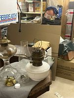 Clear glass oil lamp, milk glass base lamp, loose brass burner parts visible