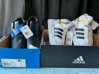 Both shoe boxes opened showing pairs: black Foray and white Entrap