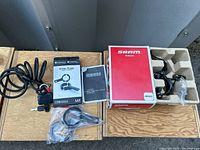 Group shot showing SRAM brakeset box, Denali light mount package, cable lock with keys