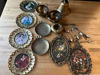 Group shot of all brass items, framed prints and spoons