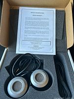 Headphones in box with warranty sheet and cable visible