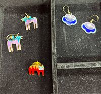 Overview of both earring pairs and brooch in case