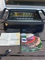 Front view of Philips indoor grill with recipe and instruction booklets