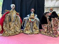 Three handmade Magi figures side by side on pink surface