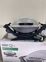 Grill on box, lid closed, showing overall appearance and branding