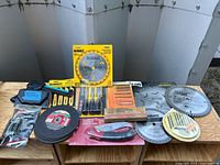 All items laid out showing variety of blades, screwdrivers, utility knife, tubing cutter, cut-off wheels, jig saw blade case and loose saw blades