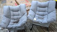 Pair of cushioned patio chairs on deck
