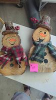 Both wood snowmen showing overall design, scarves, hats, painted features