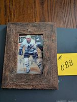Full view of framed autographed Wendell Clark photo with yellow lot card