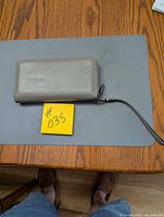 Front view of grey leather wallet with wrist strap
