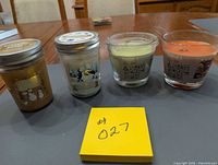 Front view of all four candles showing jars, glass holders and wax colours