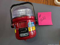 Front view of red Dorcy lantern showing label, handle, and lens