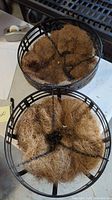 Top view of two black metal hanging baskets with coir liners