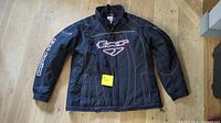 Full view of black FXR jacket laid flat