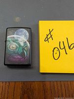 Front view showing owl and moon design on lighter