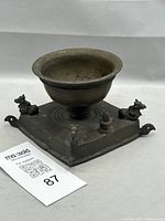 full view of brass oil lamp showing central bowl and bulls