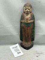 Front view of full Buddha figure showing polychrome robes and clasped hands