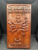 Full view of carved hardwood panel with inscriptions and figure