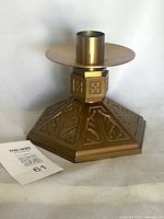 Front view of bronze altar candlestick showing overall form