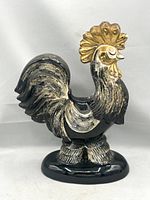 Front left view of black and gold ceramic rooster showing overall form and gilded comb