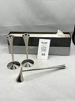 Two fluted stainless candlesticks, snuffer, box lid displayed