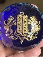 Close-up showing gilt Judaica motif and millefiori edge