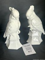 front view of both white ceramic cockatiel figures on bases