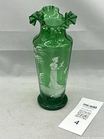 Full view of emerald green vase with ruffled rim and painted scene