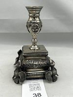 Front view of candle holder showing eagles and masks